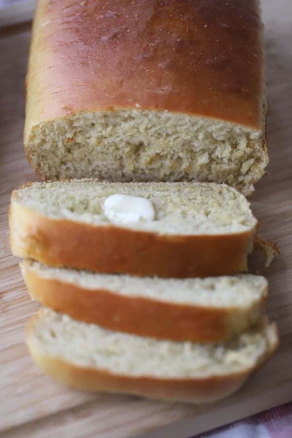 sliced white einkorn white bread on a wood cutting board, one of the easiest einkorn recipes. Einkorn sandwich bread.