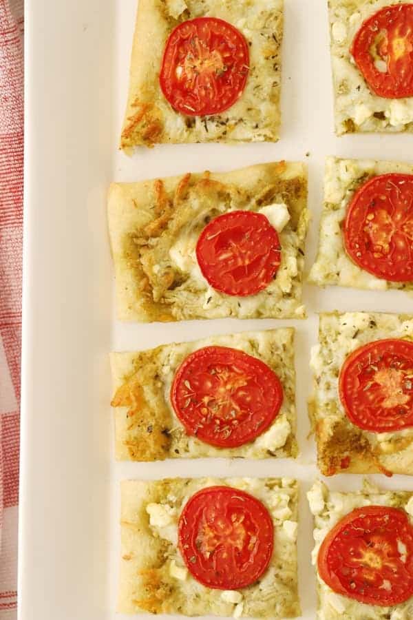 three cheese flatbread cut into rectangles on a serving platter.