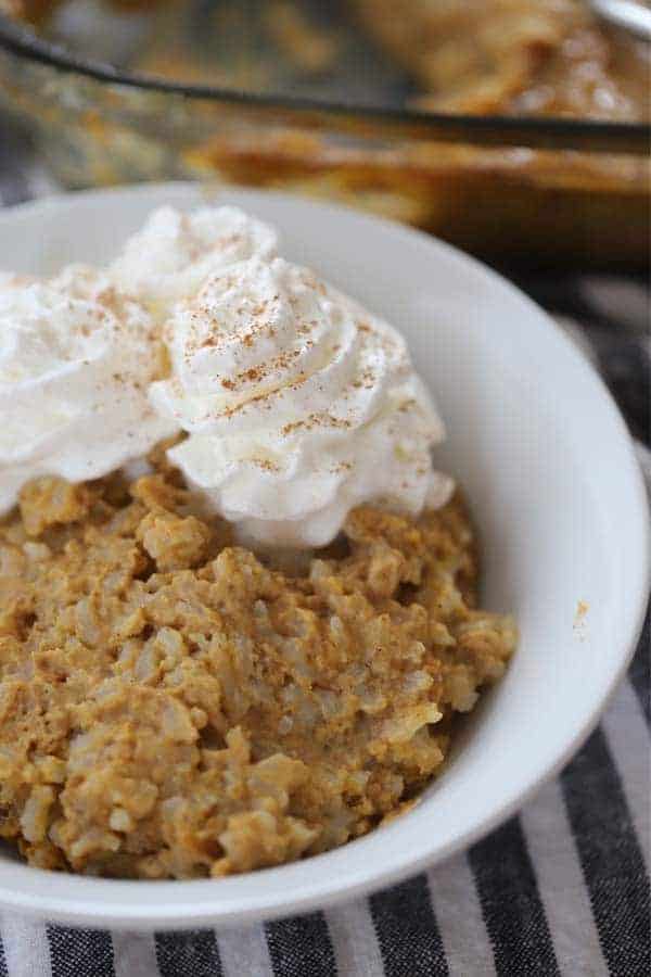 A bowl full of rice pudding topped with whipped cream and cinnamon. How to make rice pudding in the oven. Pumpkin rice pudding.