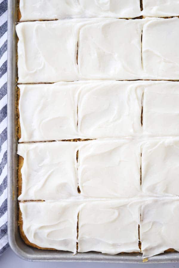 Pumpkin bars with cream cheese frosting cut and still in a baking sheet.