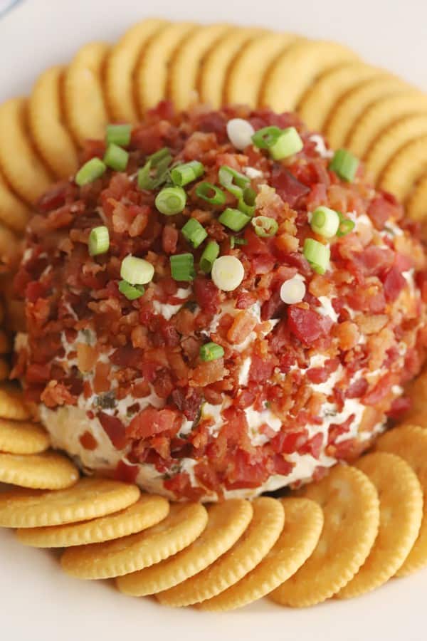 A cheese ball topped with bacon bits and green onions, surrounded by Ritz crackers. recipes with bacon bits, bacon bits recipe. 