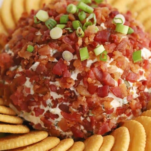 jalapeno bacon cheddar cheese ball topped with scallions and bacon bits, surrounded by Ritz Crackers.