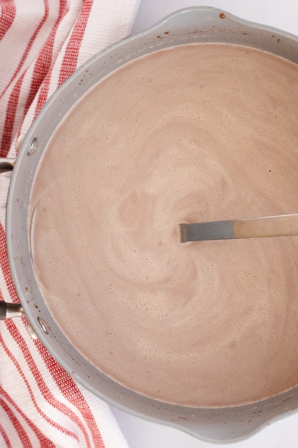 A pot full of hot chocolate with a ladle.