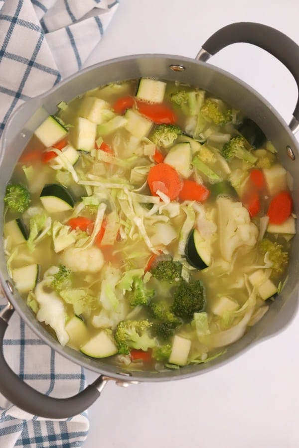 ingredients for a hearty vegetable soup in a pot, recipe for vegetable soup, best cabbage soup recipe.