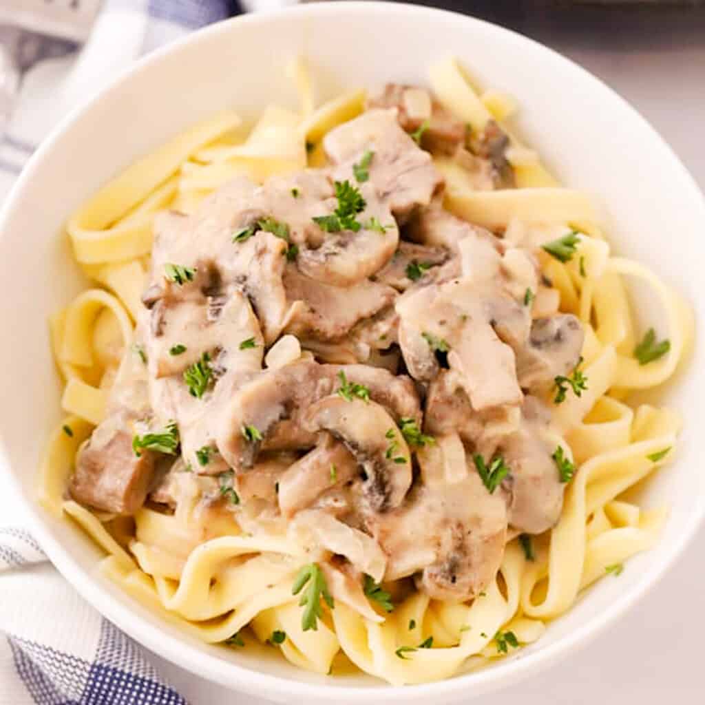 beef stroganoff recipe in a white bowl, traditional beef stroganoff recipe.