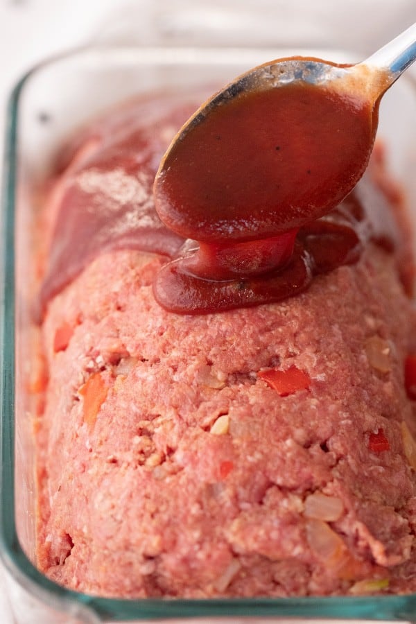 raw meatloaf in a pan with a meatloaf glaze, traditional meatloaf recipe. meatloaf temp and time. 