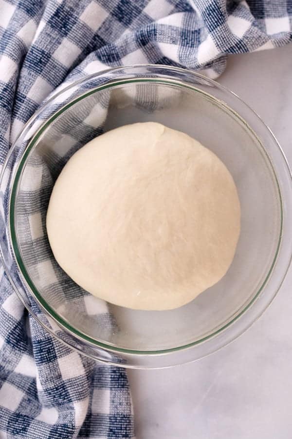 how to prep homemade pizza dough recipe, homemade dough in a glass bowl, how to bake pizza dough, pizza dough temperature