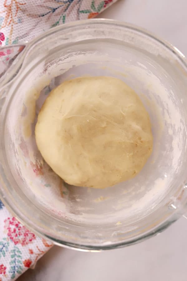 a ball of yeast dough in a glass bowl, ready for breadsticks, pizza or rolls. 