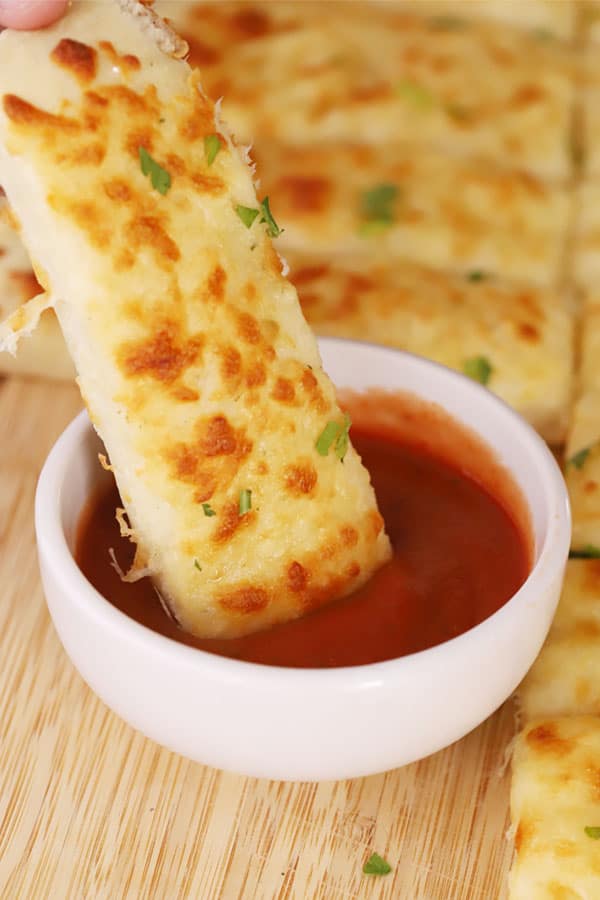 homemade cheesy breadsticks  dipped in marinara sauce, mozzarella cheese breadsticks, recipe for cheesy breadsticks.