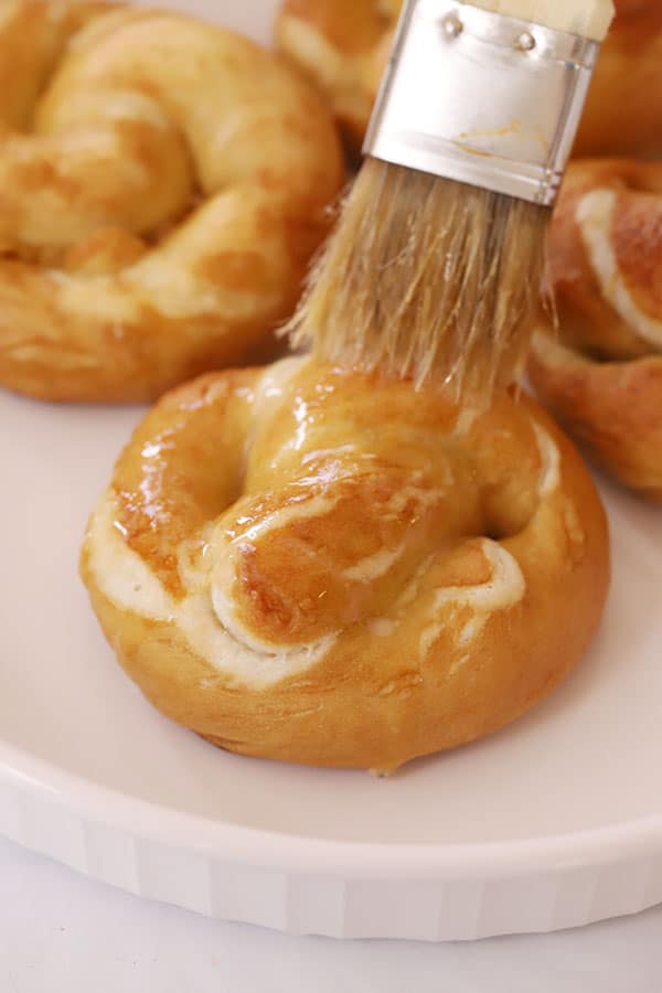 buttering a freshly made pretzel