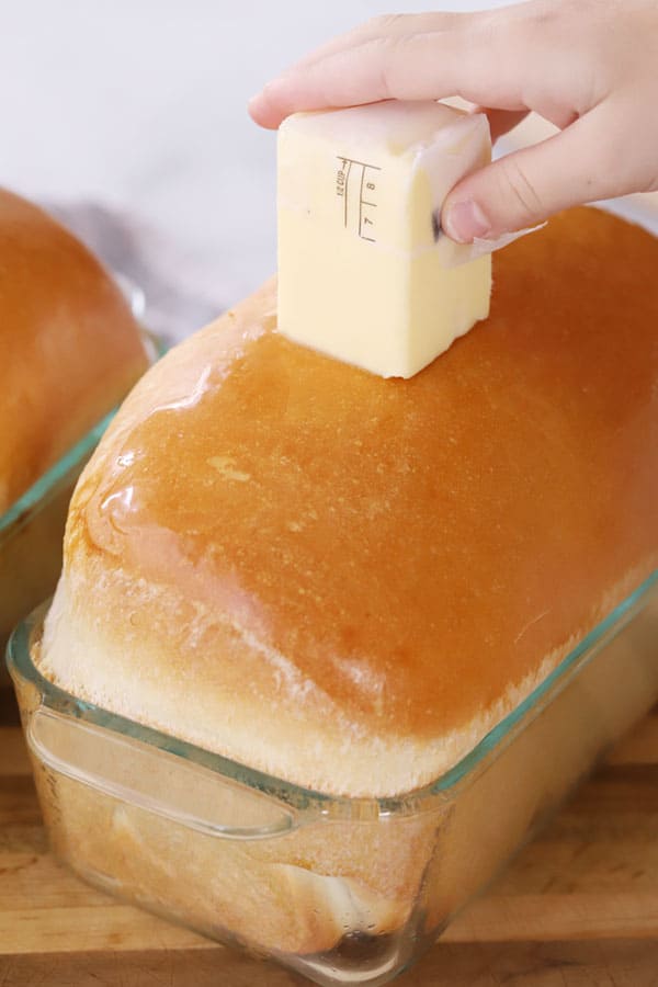 recipe for white bread, homemade white bread in a loaf pan, butter top of bread, homemade white bread recipe. 