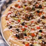 taco pizza drizzled with salsa creamy sauce