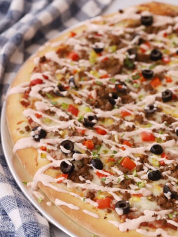 taco pizza drizzled with salsa creamy sauce