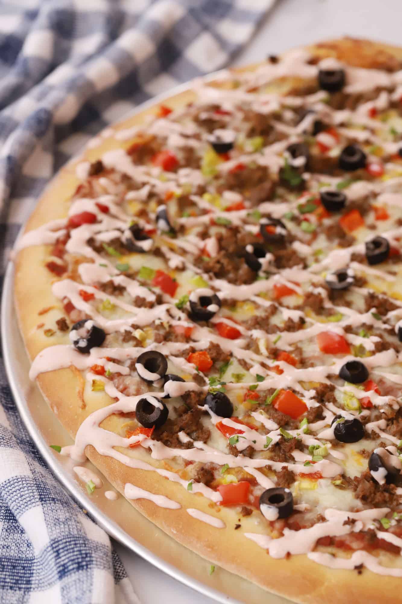 Taco pizza drizzled with creamy salsa sauce