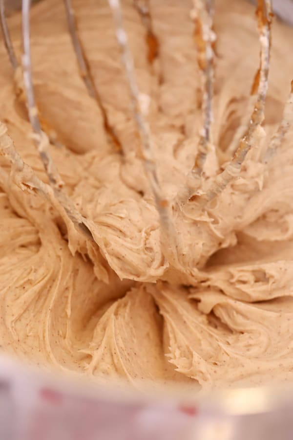 cinnamon butter cream frosting, light and fluffy in metal mixing bowl, cinnamon frosting.