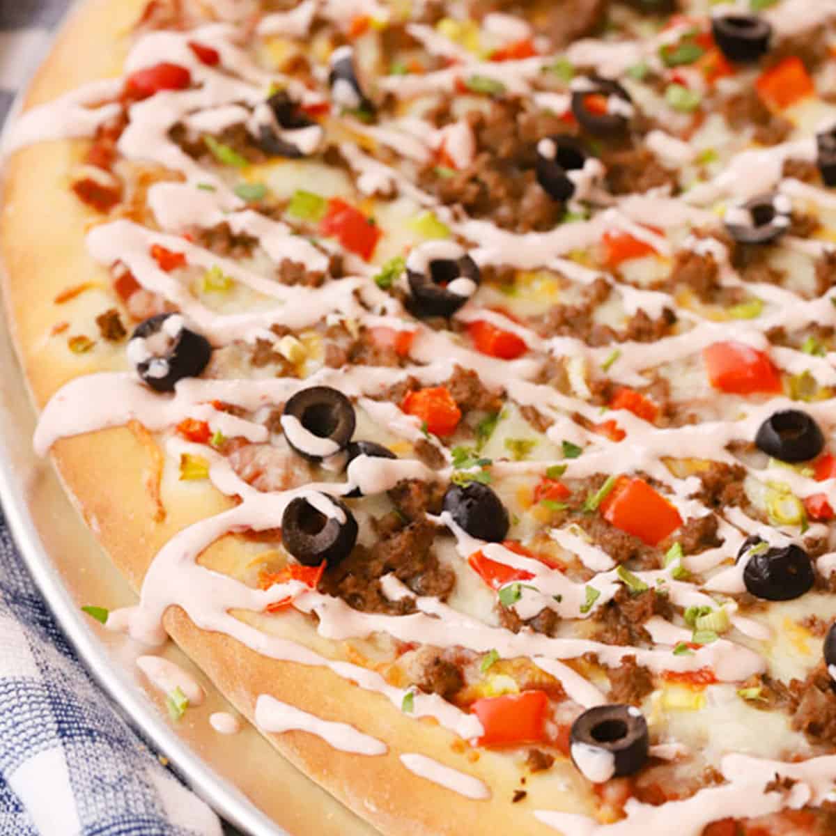 taco pizza- a homemade taco pizza drizzled with salsa creamy sauce