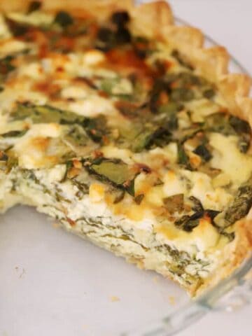 a slice of spinach quiche missing from the pie plate