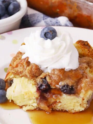 blueberry french toast bake on a plate with fresh blueberries and whipped cream on top, best breakfast recipe