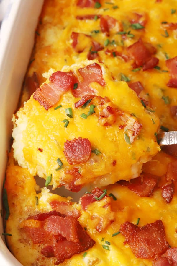 scooping out tater tot breakfast casserole, breakfast casserole recipes with tater tots. bacon casserole, tater tot egg bake, tater tot egg casserole, breakfast tater tot casserole. 