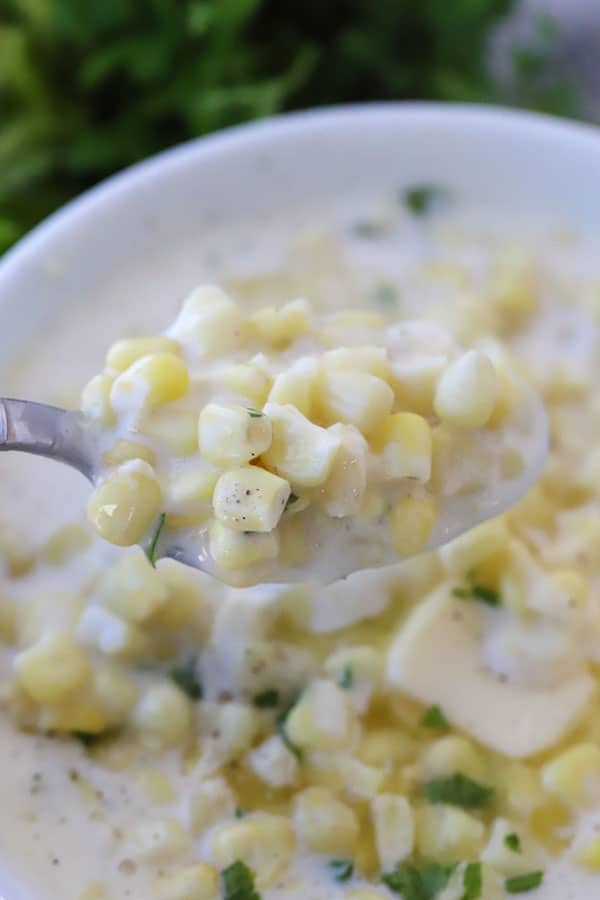 creamed corn recipe on a spoon, a holiday side dish recipe, homemade cream corn.