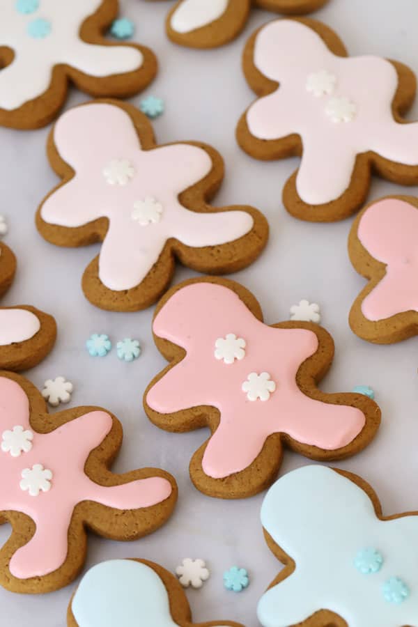 Gingerbread man cookies decorated with colored royal icing and snowflake candies.