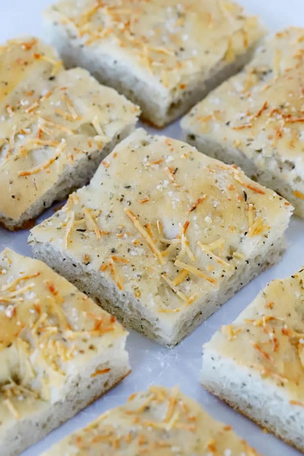 herb focaccia bread cut up into squares to be served, a great bread recipe. 