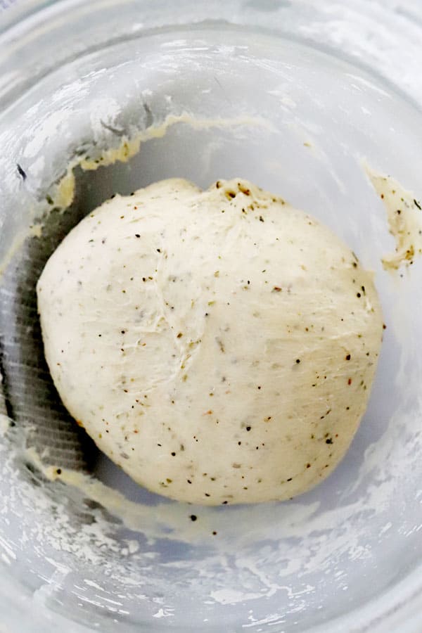 herb focaccia bread dough in a mixing bowl.