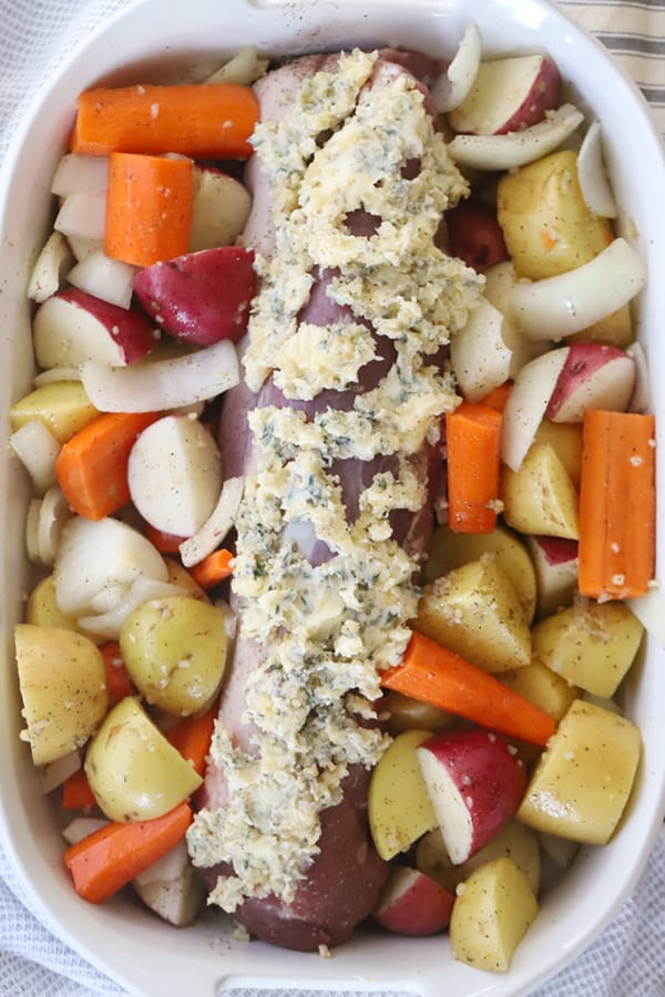 pork tenderloin and potatoes and carrots covered in herb butter and vegetables, an easy pork roast and vegetables recipe.