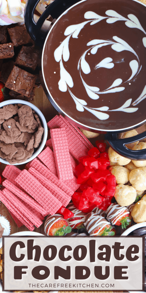 Melted chocolate fondue in a large dutch oven surrounded by various cookies and candies for dipping.