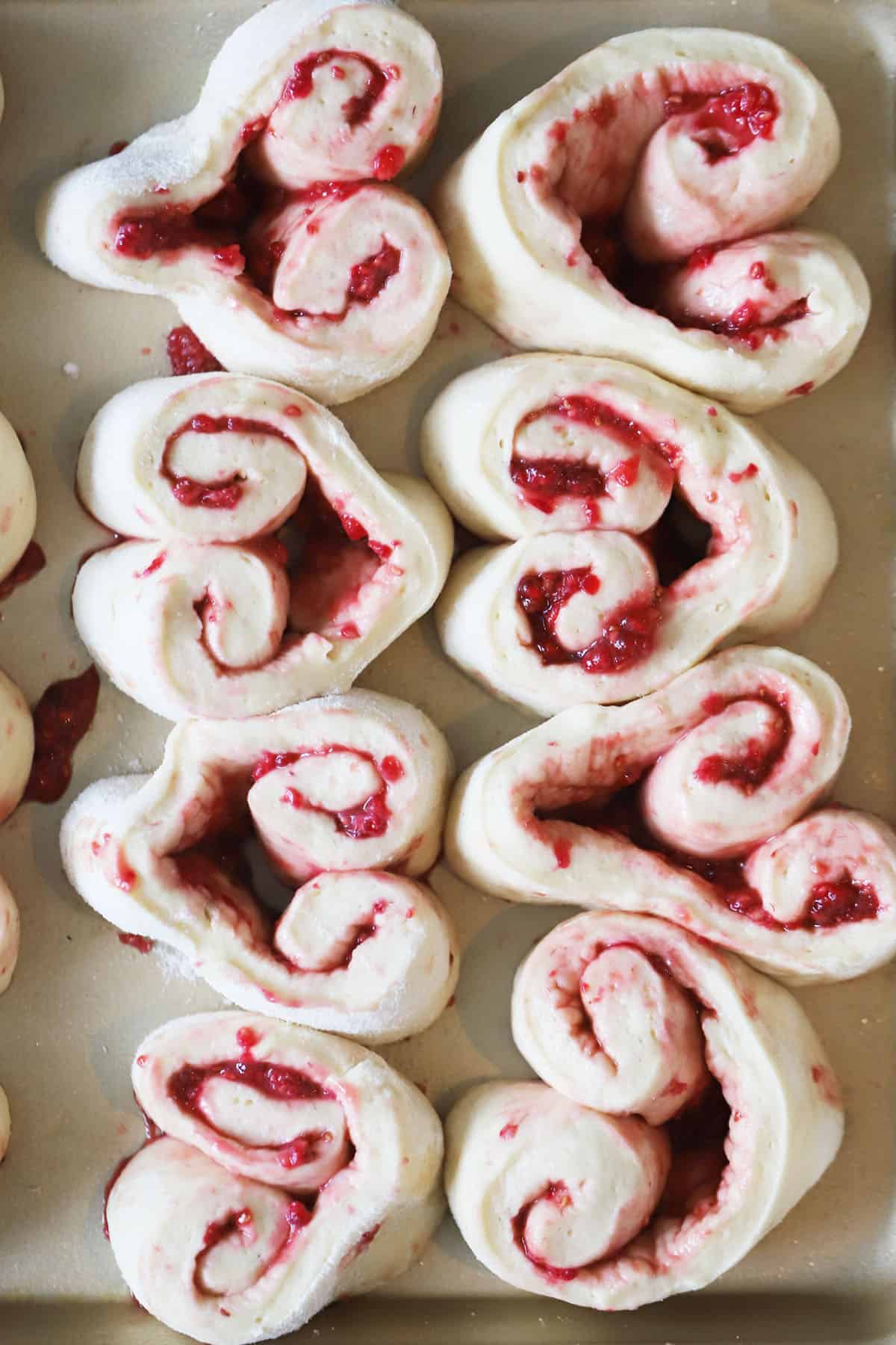 raspberry sweet rolls before baking on a a large baking sheet, raspberry cinnamon rolls.