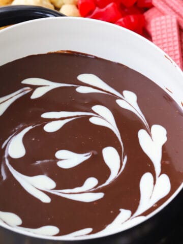 milk Chocolate fondue recipe with white chocolate hearts in a fondue pot, how to make chocolate fondue. best chocolate fondue recipe.