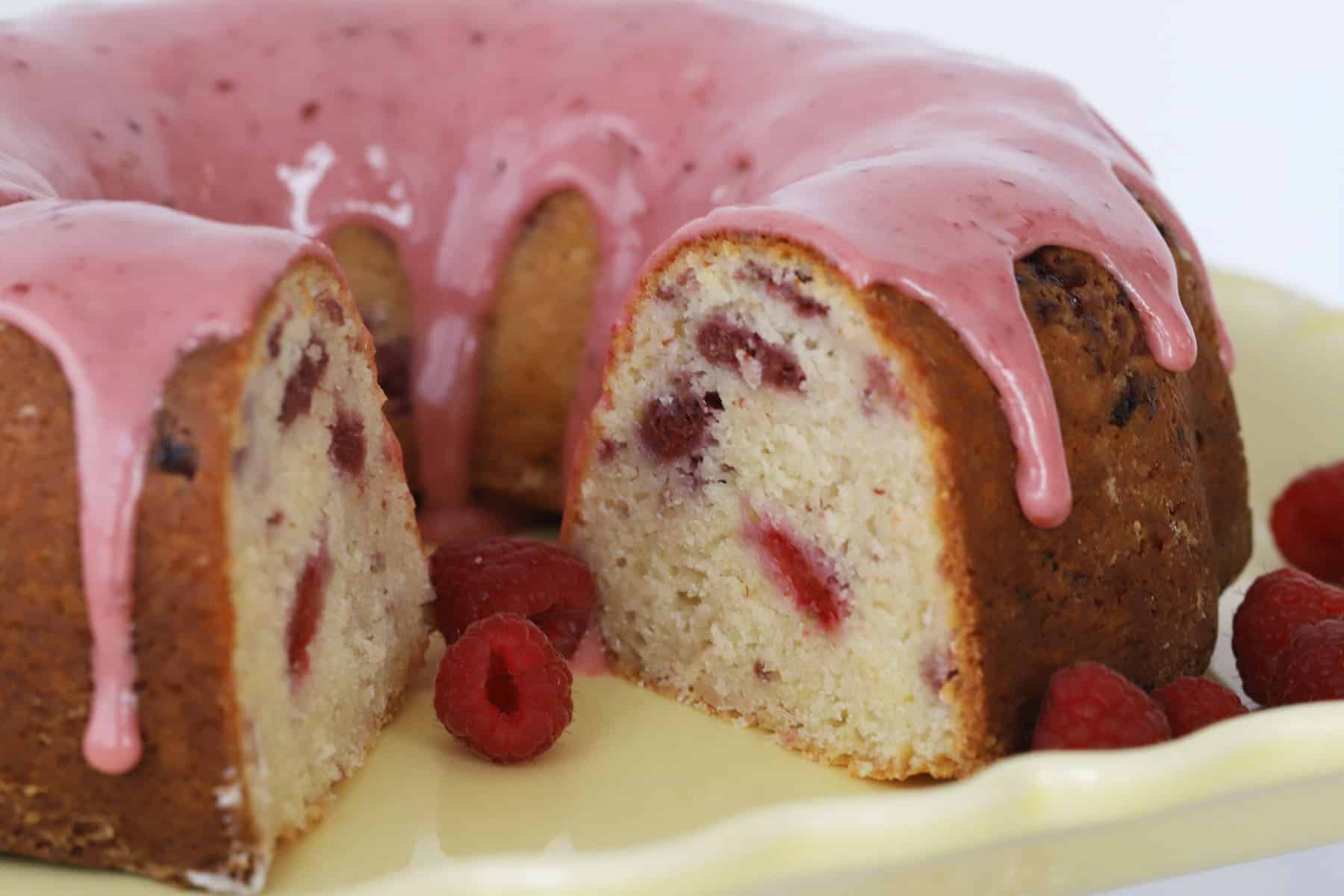 Bundt cake with a slice cut out, glazed with raspberry glaze.