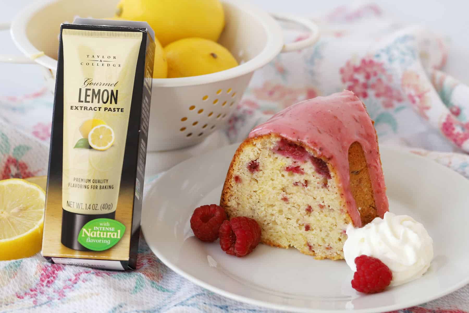 A white plate with a slice of raspberry lemon bundt cake with raspberry jam glaze.