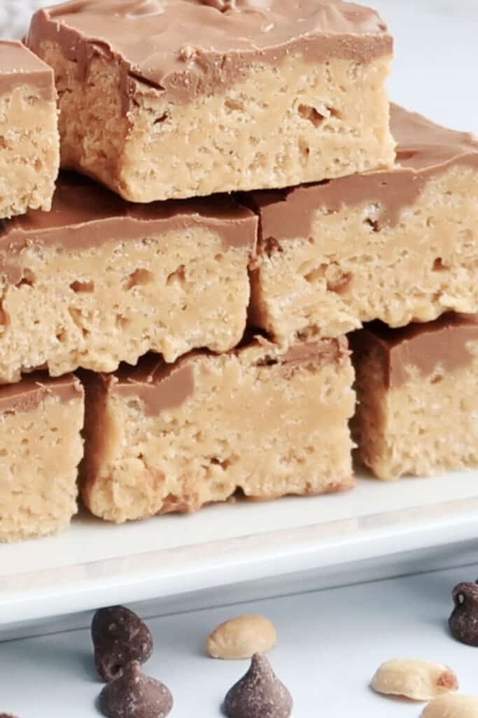 Scotcharoo bars stacked on top of each other on a plate. no bake cookie bars recipe. no bake squares.