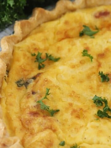 bacon asparagus Quiche on a plate, ready to be served warm or cold. baon asparagus quiche, asparagus quiche.