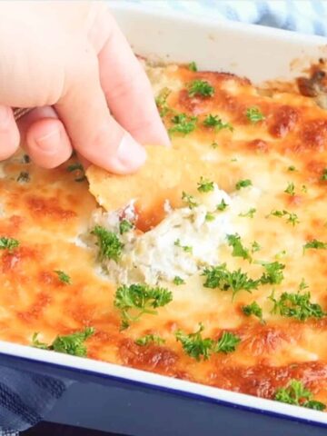 artichoke dip recipe, Corn chip being dipped in jalapeno Artichoke Dip recipe.