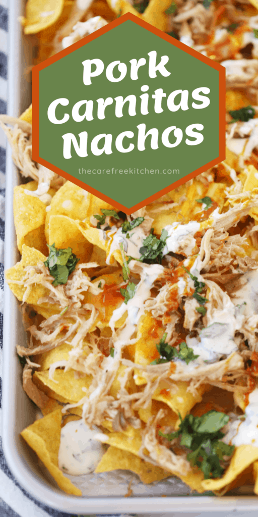 A sheet tray full of nachos topped with carnitas, cheese and more.