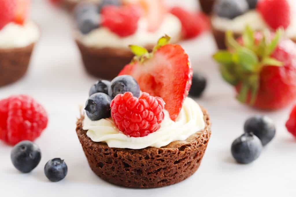 the best brownie bites recipe, cream cheese frosting brownies topped with fresh fruit.
