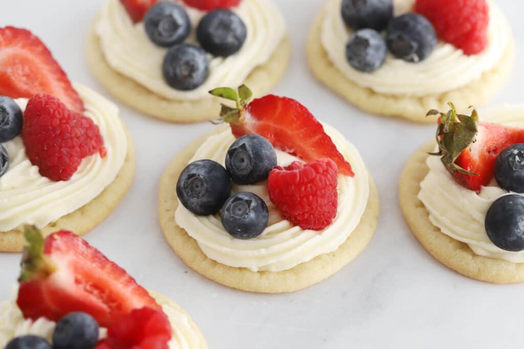 fruit pizza with cream cheese frosting, topped with berries.