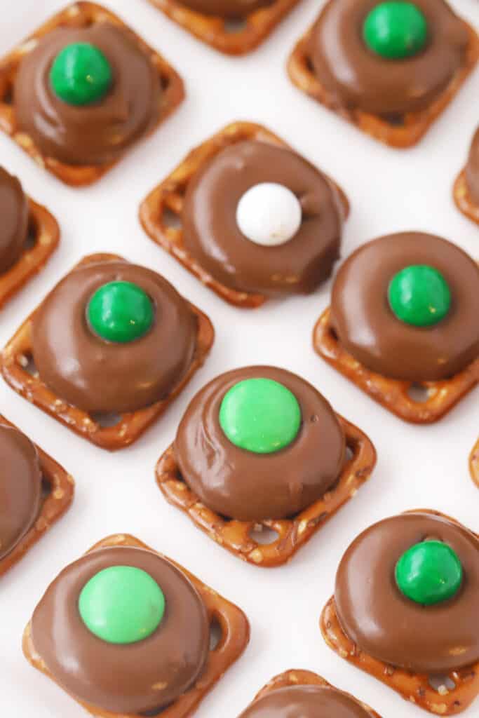 A tray with homemade candies lined up made from pretzels, rolos and decorated with chocolate candies on top.