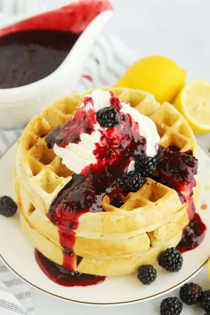 A stack of Belgian Waffles on a white plate, topped with whipped cream and berries. red white and blue food ideas, red white blue food . 