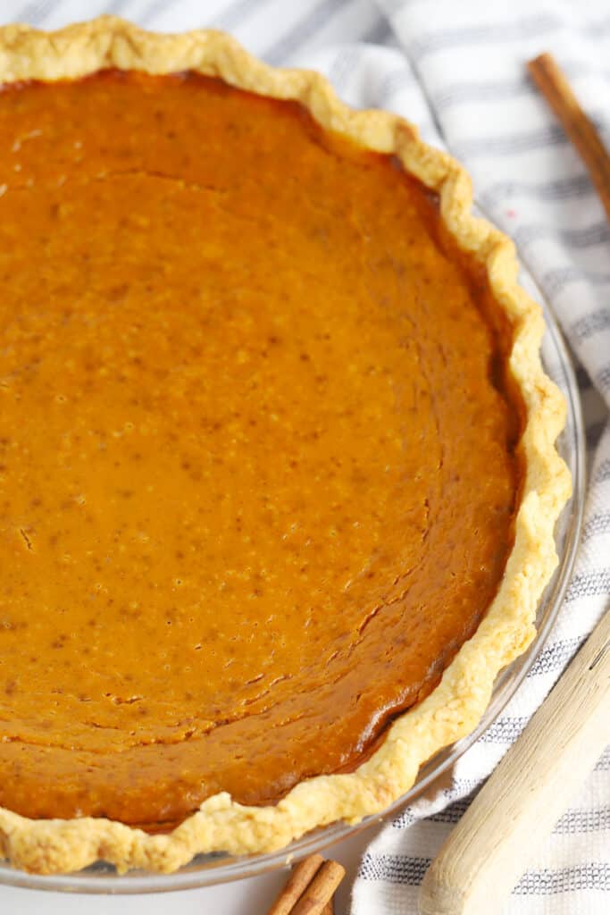 A baked pumpkin pie in a pie dish, pumpkin pie recipe from scratch.