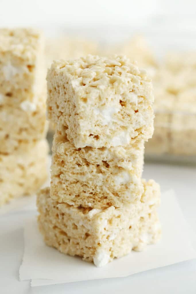 Classic Rice Krispies Treats cut into squares and stacked on top of each other. no bake cookies bars. easy no bake cookies bars