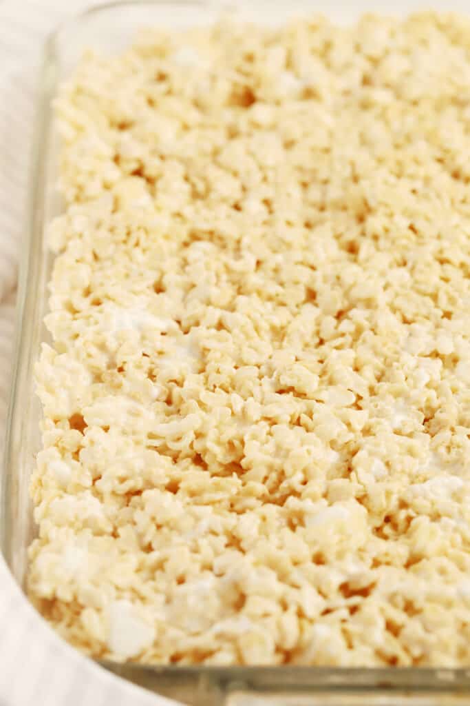 A baking dish full of chewy Rice Krispies Treats prior to cutting.