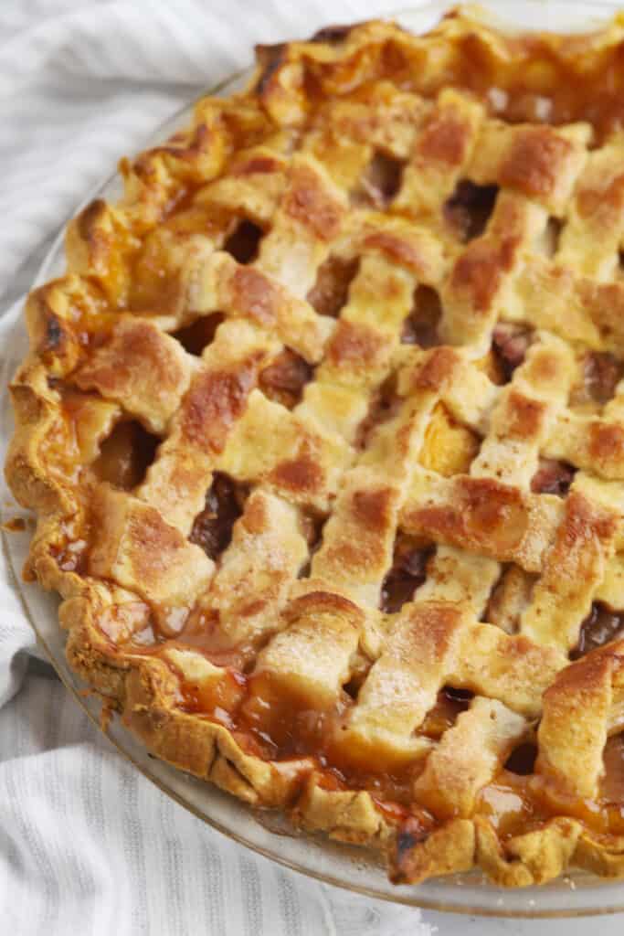 A full pie baked inside a pie plate with a lattice top crust.