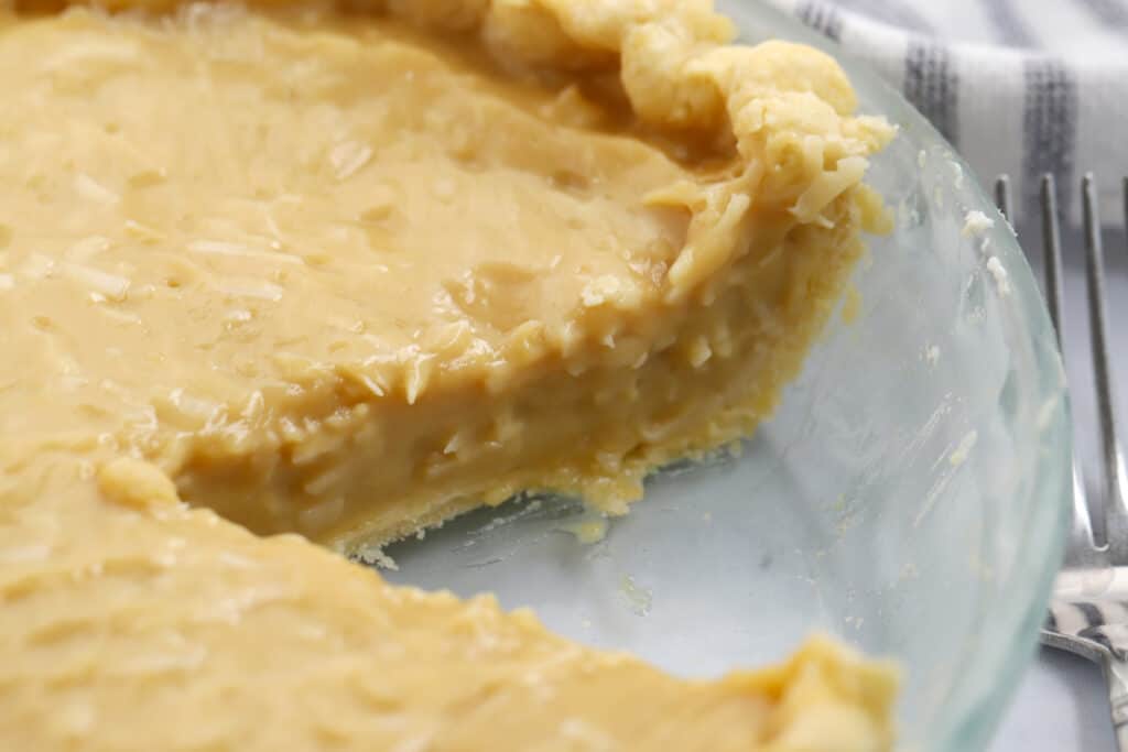 A recipe for butterscotch pie baked in a pie dish with a slice removed.