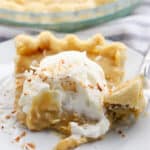 A slice of coconut pie topped with whipped cream on a pie plate. butterscotch pie recipes.