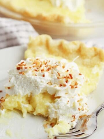 a slice of coconut cream pie on a white plate, how to make coconut cream pie.
