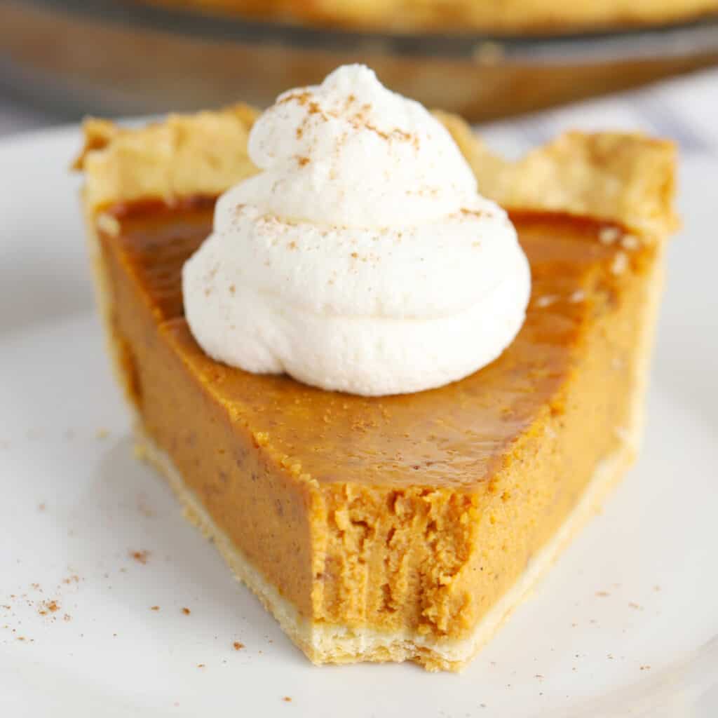 A slice of pumpkin pie with a bite removed.