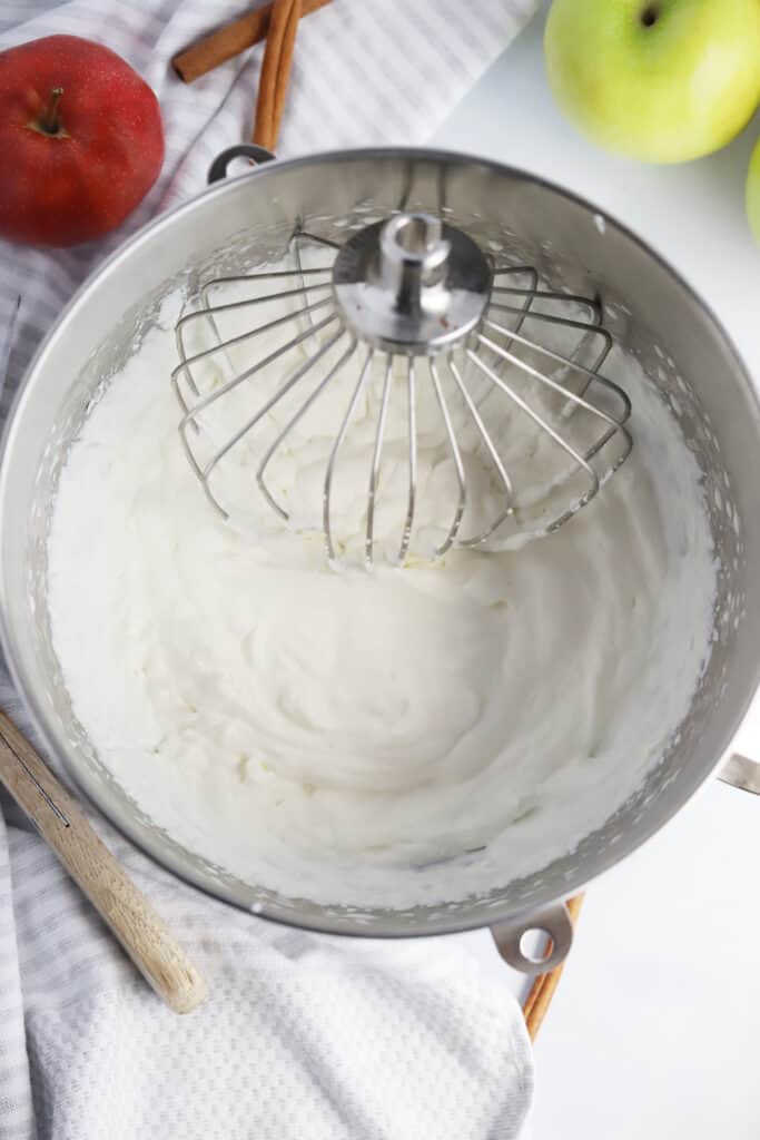 A mixing bowl full of fresh whipped cream. how to sweeten whipped cream confectioners sugar. Recipe for sweetened whipped cream.